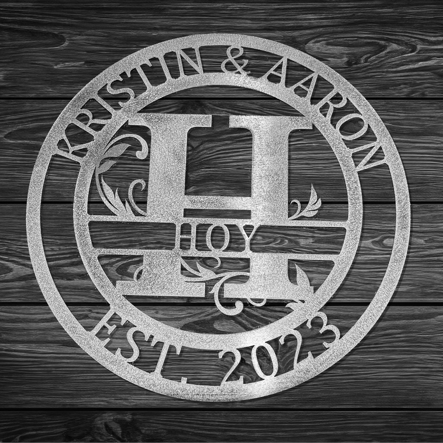 Round Scroll Monogram with Top Personalization and EST Date Raw Steel H with "KRISTIN & AARON HOY EST 2023" personalization on gray wood background