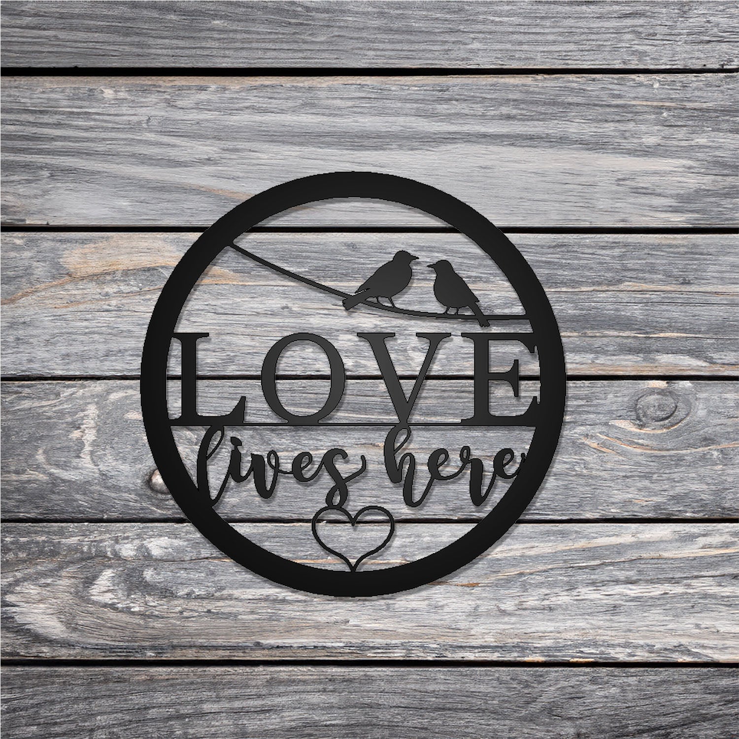 Love Lives Here Round Metal Sign on wood background