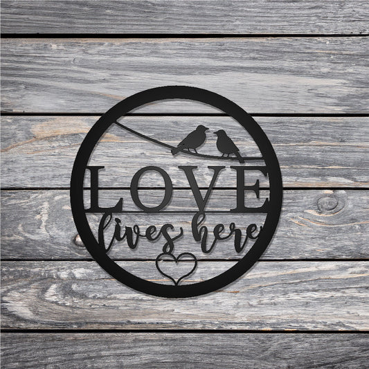 Love Lives Here Round Metal Sign on wood background