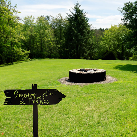 S'mores This Way Arrow Metal Sign - Staked shown in grassy yard with a firepit