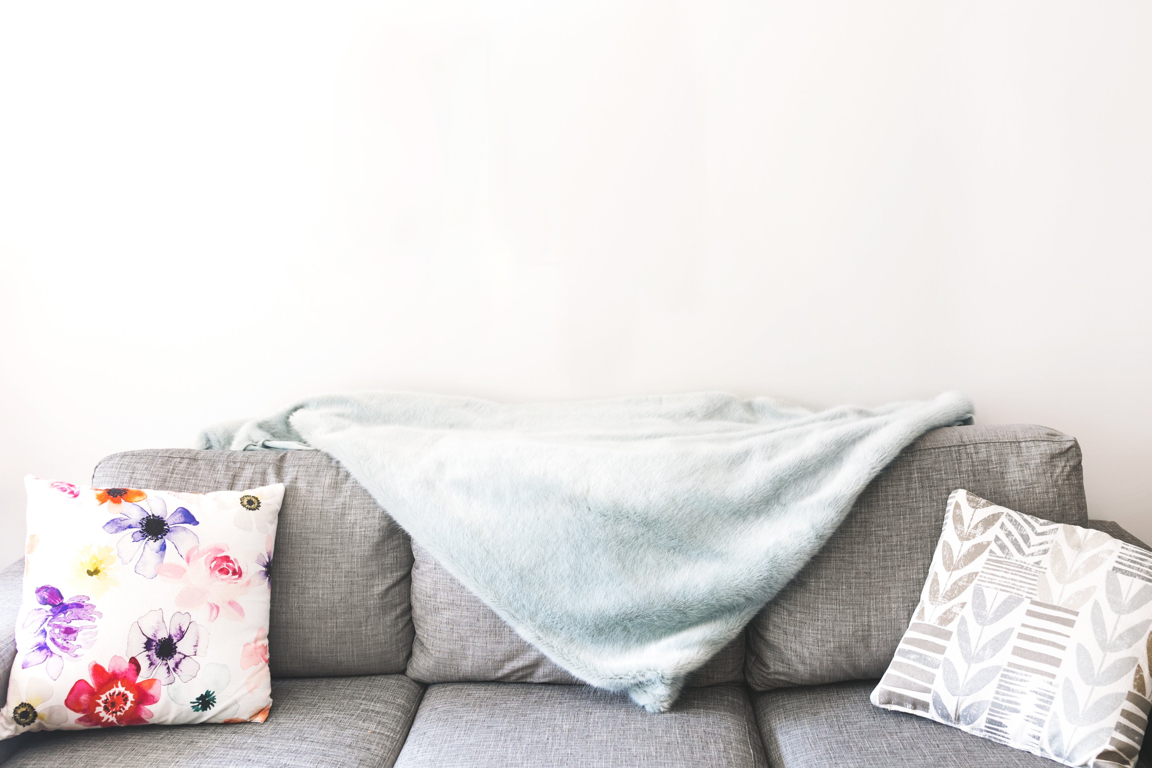 Bare wall behind decorated couch, in need of a metal sign