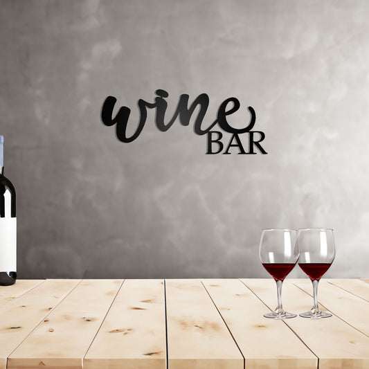 Wine Bar Script Metal Sign on a wall behind a wooden top bar with wine bottle and glasses