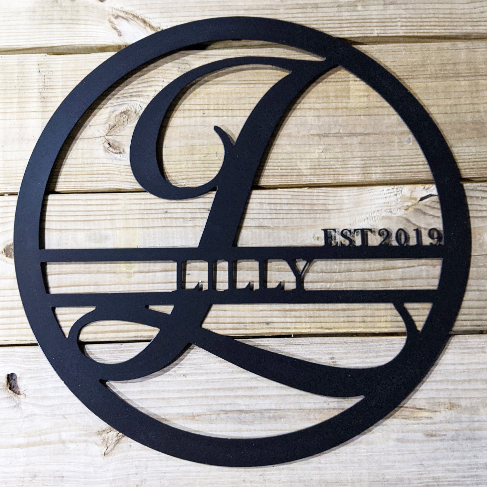 Personalized Round Family Name with Initial & Established Date Metal Sign with "LILLY 2019" personalization on wood plank background