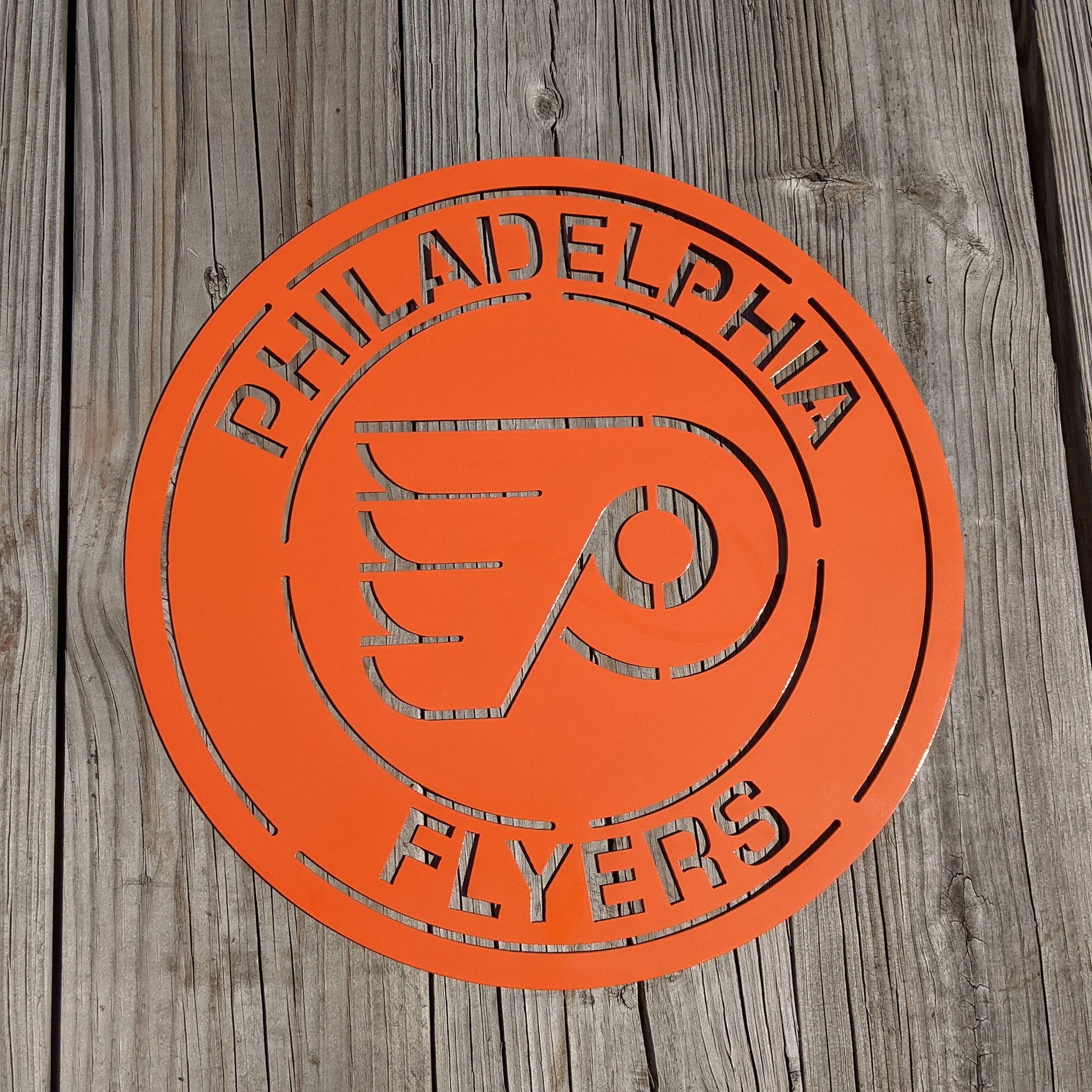Flyers Logo Round Metal Sign Orange on wood background
