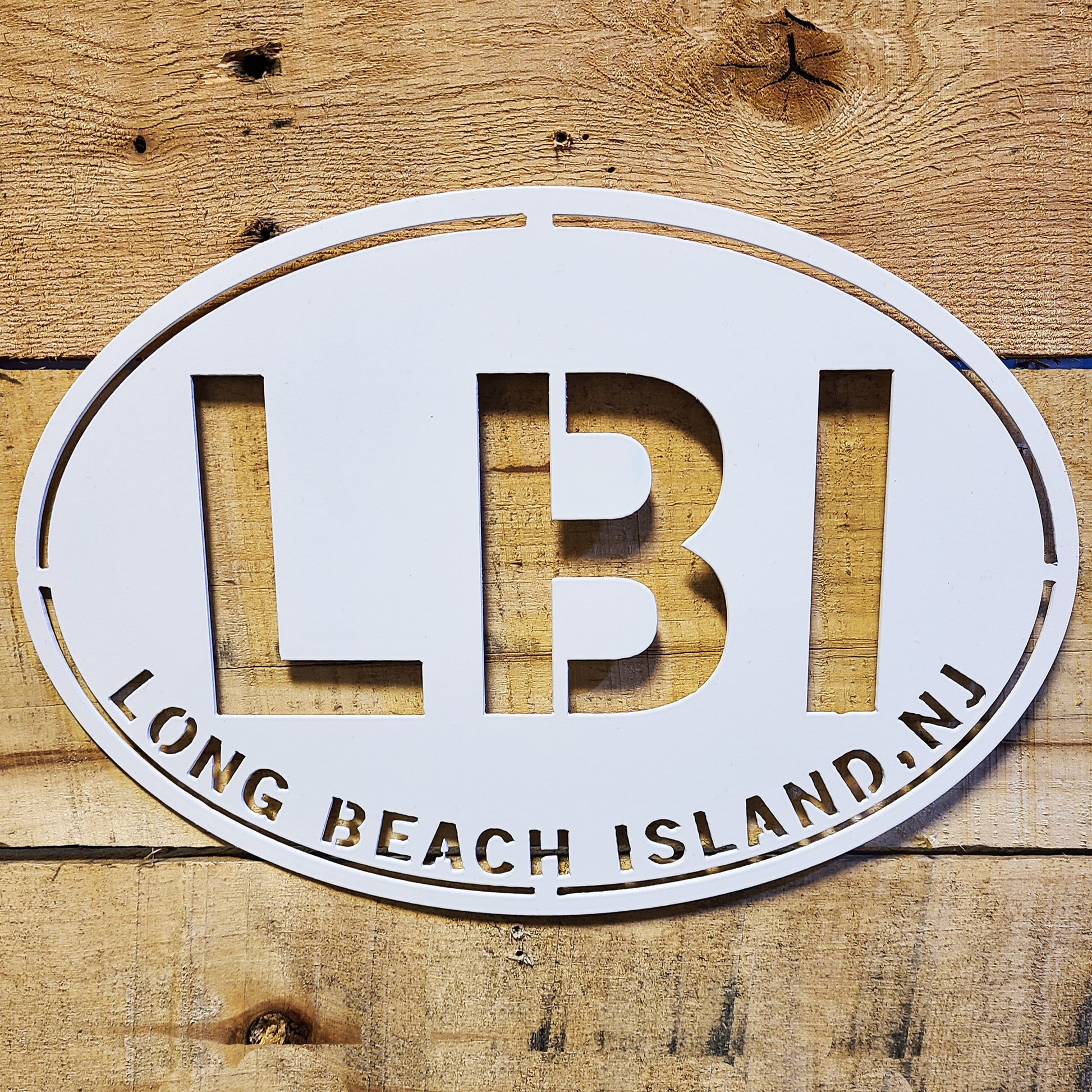 LBI New Jersey Oval Metal Wall Sign White on wood plank background