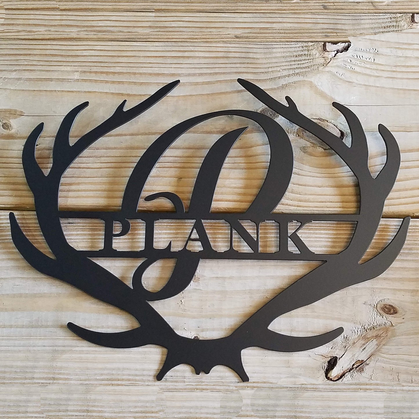 Antler Rustic Family Name Monogram Metal Sign on a wood background